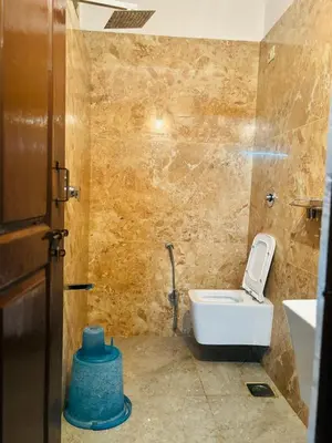 a bathroom with a toilet and a sink at Avini Stay in Mysore