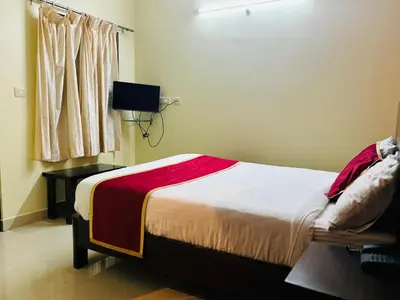 a bedroom with a bed and a window at Avini Stay in Mysore