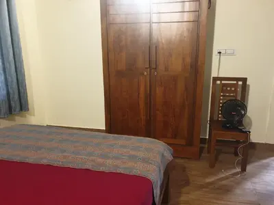 a bedroom with a large wooden cabinet and a bed at Farmville Riverside in Kakkayam