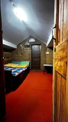 a room with two beds and a door at Alpine Mud house Kanthalloor in Kanthalloor