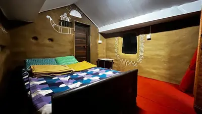 a bedroom with a bed with a mural on the wall at Alpine Mud house Kanthalloor in Kanthalloor