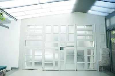 a white garage door in a white room at Malhar - Your Home Beneath The Clouds in Sultan Bathery