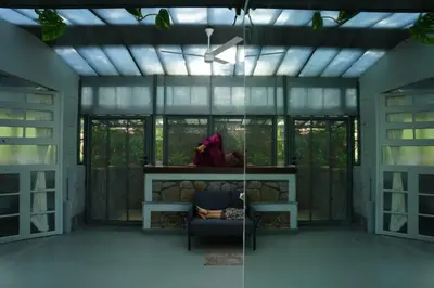 a living room with a chair and a window at Malhar - Your Home Beneath The Clouds in Sultan Bathery