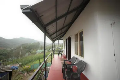 a balcony with chairs and a view of a mountain at Drizzling Home Stay in Vattavada