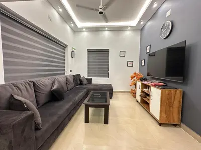 a living room with a couch and a flat screen tv at The Chill Spot in Karuvapadna