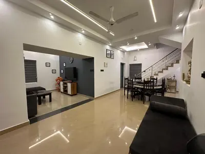 a living room with a table and a dining room at The Chill Spot in Karuvapadna