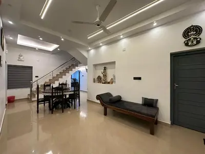 a living room with a black couch and a table at The Chill Spot in Karuvapadna
