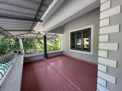 a balcony of a house with a red floor at The Chill Spot in Karuvapadna