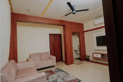 a living room with a couch and a flat screen tv at Atland Residency in Calicut