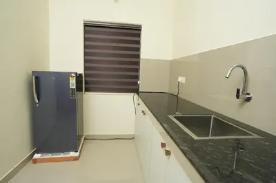 a kitchen with a sink and a counter top at Atland Residency in Calicut