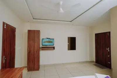 a living room with a tv on a white wall at Atland Residency in Calicut