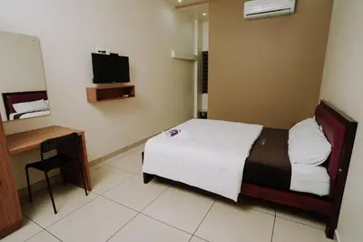 a hotel room with a bed and a desk at Atland Residency in Calicut