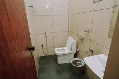a bathroom with a toilet and a sink at Atland Residency in Calicut