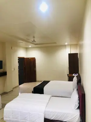 a hotel room with two beds and a door at Atland Residency in Calicut