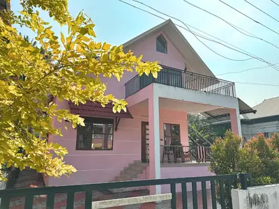 a pink house with a balcony on top of it at Chakkantharas Pool Villas in Athirappilly