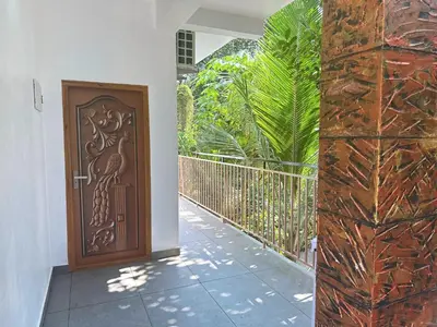 a wooden door in a house with a balcony at Chakkantharas Premium Villa in Athirappilly