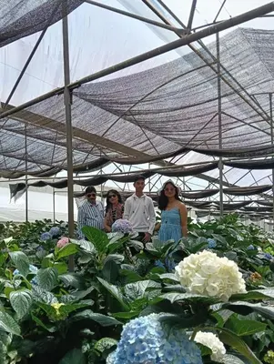 a group of people standing in front of some flowers at Longwood Resorts in Kotagiri