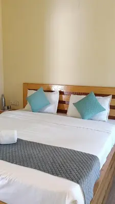 two beds in a room with blue and white pillows at Longwood Resorts in Kotagiri