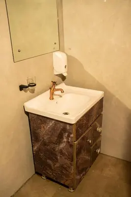 a bathroom sink with a soap dispenser above it at Yaala - Coorg Riverside Retreat in Napoklu