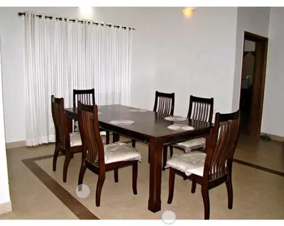 a dining room table with four chairs and a wooden table at Deep view luxury villa Coffee Cottage Coorg in Madikeri