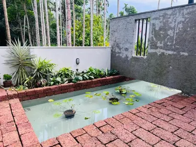 a pond filled with water lilies on a brick floor at RiverMist Resort in Nilambūr