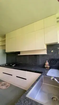 a kitchen with white cabinets and a sink at RiverMist Resort in Nilambūr