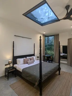 a bedroom with a large bed with a skylight at Birdsong Luxury Pool Villa by Luxunlock Private Villas in Suntikoppa