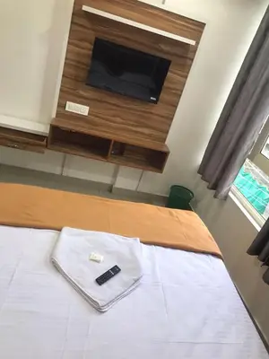 a bedroom with a bed with a tv and a cell phone at low budget room at Kalpetta in Kalpetta