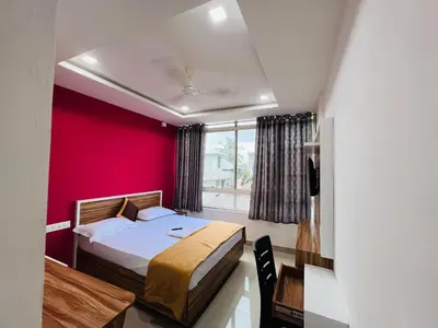 a bedroom with a bed and a red wall at low budget room at Kalpetta in Kalpetta