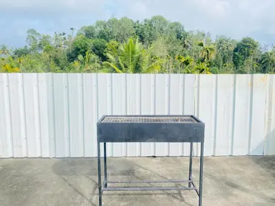 a table sitting in front of a white fence at Homie Hub in Meppādi