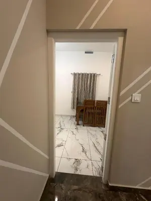 a door leading into a room with a tile floor at Homie Hub in Meppādi