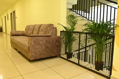 a living room with a couch and some plants at Cous Cous Residency Hotel in Padinjarathara