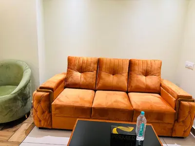 a brown leather couch in a living room with a table at Cous Cous Residency Hotel in Padinjarathara