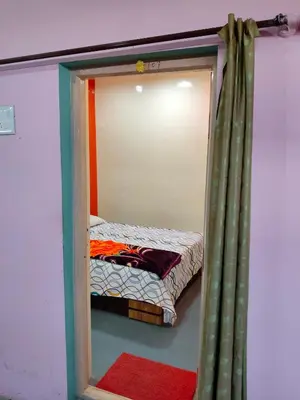 a small bed in a room with a mirror at Sri Vinayaka Tourist Home in Nanjangūd