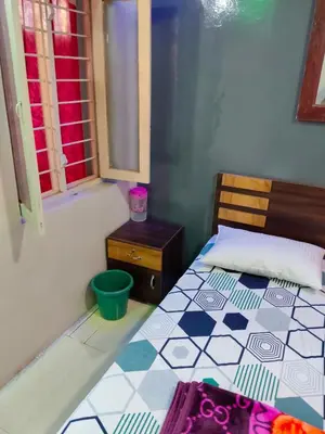 a bedroom with a bed with a tiled floor at Sri Vinayaka Tourist Home in Nanjangūd