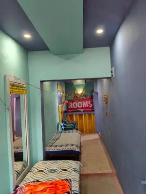 a room with two beds and a room with a sign at Sri Vinayaka Tourist Home in Nanjangūd