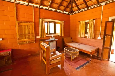 a room with a bench and a table and a chair at Kabbe Hillview Homestay in Madikeri