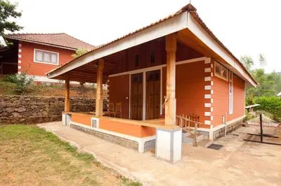 a small wooden house with a large porch at Kabbe Hillview Homestay in Madikeri
