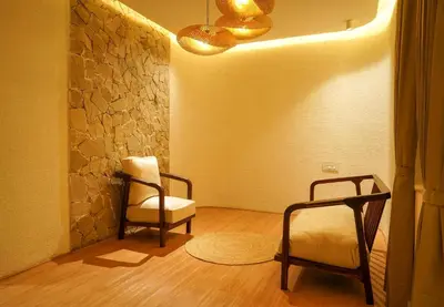 a room with two chairs and a table and a wall at Virgin Valley Leisure Resort in Ooty
