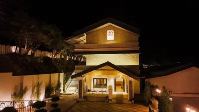 a large building with a sign on it at night at Virgin Valley Leisure Resort in Ooty