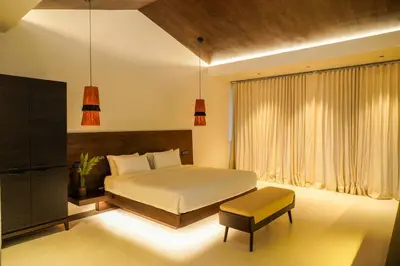 a bedroom with a bed and a bench and a window at Virgin Valley Leisure Resort in Ooty