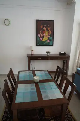 a dining room table with chairs and a painting on the wall at Perfect Gateway in Mysore