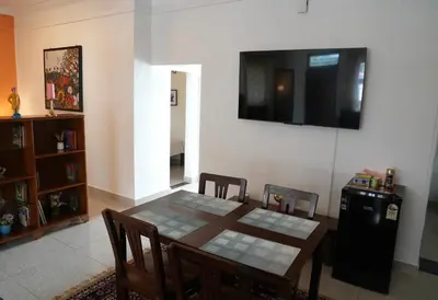 a dining room with a table and a television on the wall at Perfect Gateway in Mysore