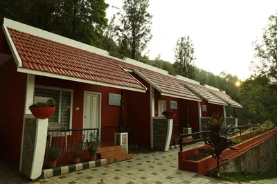 a row of red buildings with plants in front of them at Velu's Resort in Gūdalūr