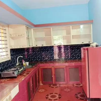 a kitchen with red cabinets and a pink refrigerator at Aghasthyashrya Homestay in Siddapur
