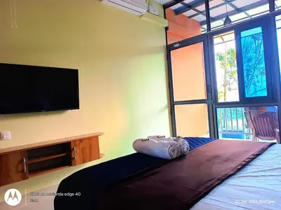 a bedroom with a bed and a flat screen tv at Goldenpeak Estate-Homestay-3Bed-A frame Holiday Home in Wayanad