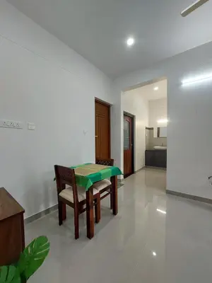 a dining room with a green table and chairs at Achandy Arcade in Kakkadampoyil