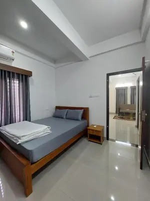 a bedroom with a bed and a mirror in it at Achandy Arcade in Kakkadampoyil