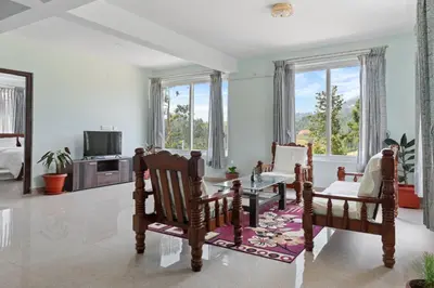 a living room with a table and chairs and windows at BVK Mount Home in Ketti