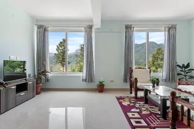 a living room with a couch and a tv and windows at BVK Mount Home in Ketti
